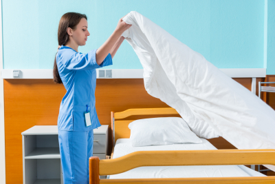 nurse changing bedsheets